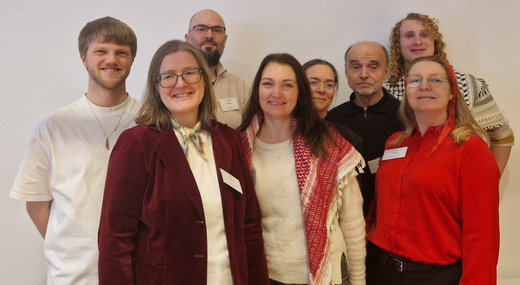 Åtte styremedlemmer ser inn i kamera og smiler. 